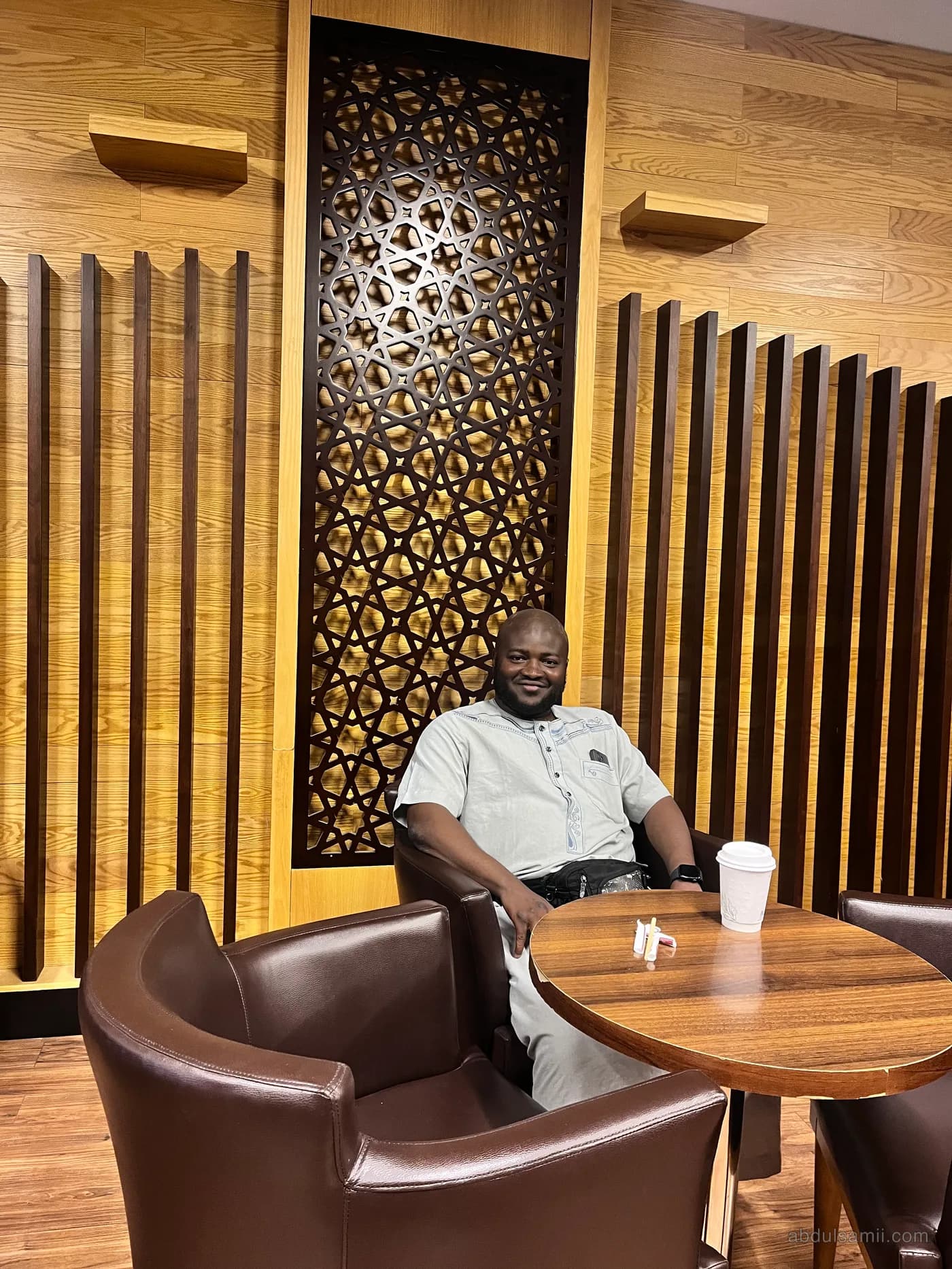 Abdulsamii seated in a wood-panelled lounge