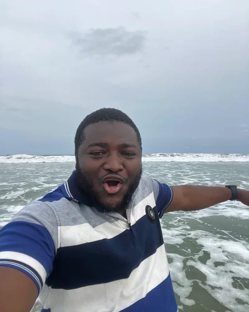 Abdulsamii grinning on a boat with waves behind him