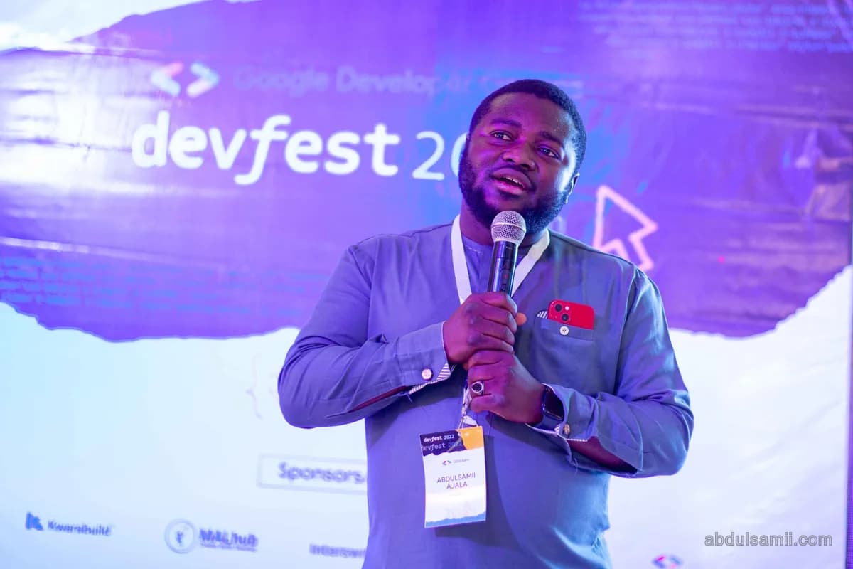 Abdulsamii speaking on stage with a microphone at DevFest